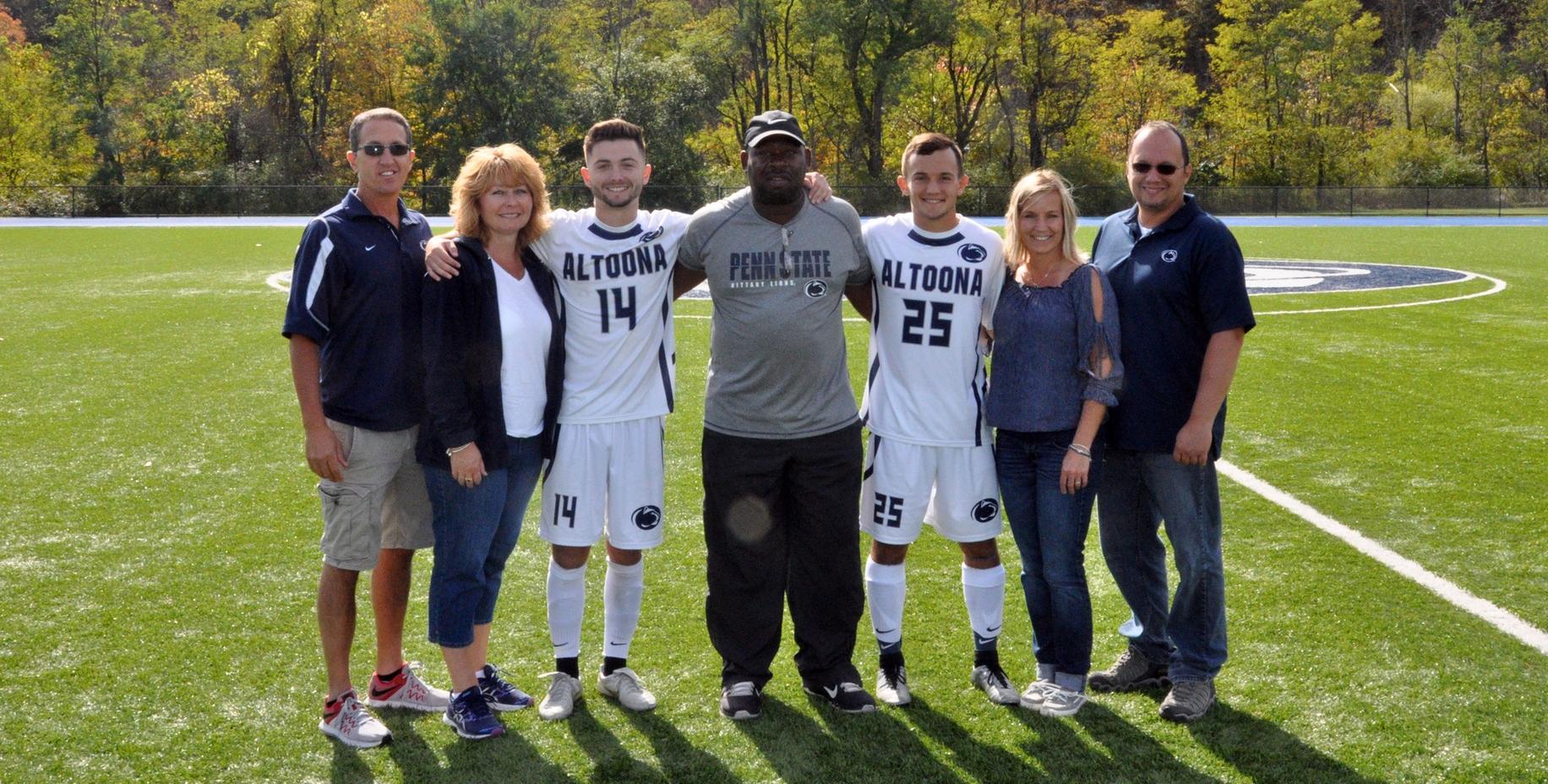 Photo: Penn State Altoona seniors #14 Seth Murrelle and #25 Coltin Ebersole pose with their families during the pregame Senior Day ceremony on Saturday.