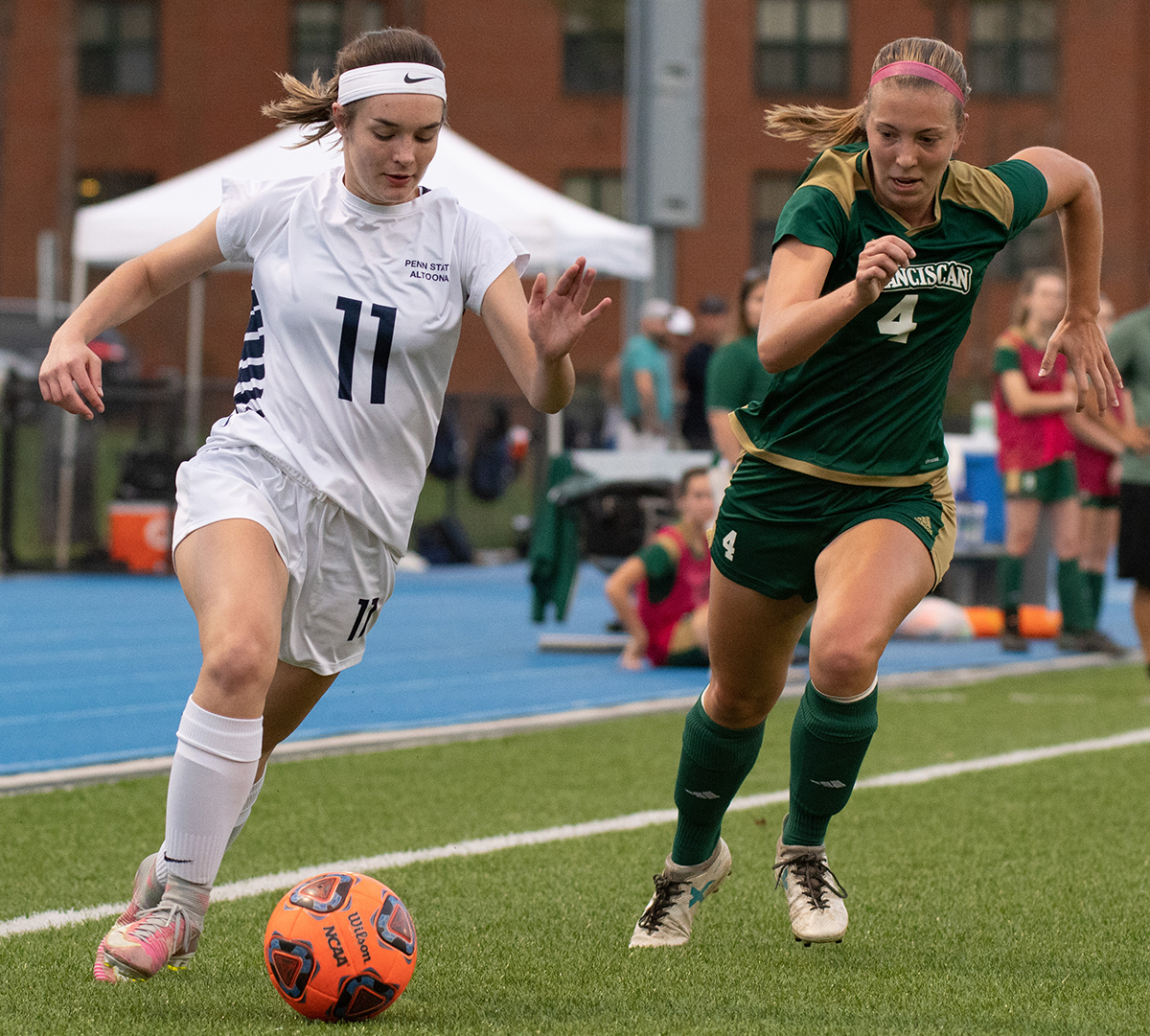 Photo (by Noah Riffe): Penn State Altoona freshman forward Sadie McConnell dribbles past Franciscan's Kelsey Scott-Avery during Tuesday night's game at Spring Run Stadium.