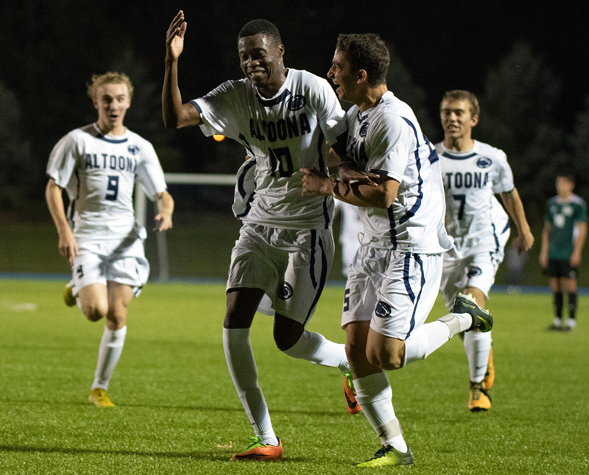 Photo (by Noah Riffe): Lions sophomore forward #10 Erikson Miguel celebrates with teammates after scoring the go-ahead goal during Tuesday night's win over Franciscan at Spring Run Stadium.