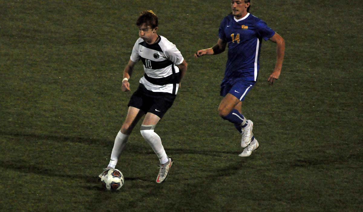 Photo: Freshman Ciaran Corr dribbles the ball away from a Pitt-Greensburg player during Wednesday night's win.